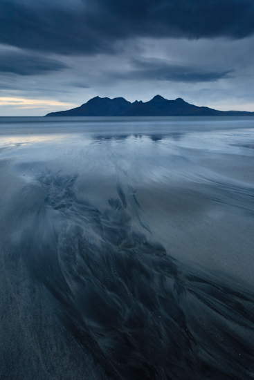 Het gekleurde zand op Laig Bay leidt het oog naar Isle of Rum